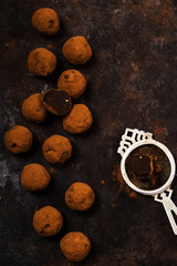 Dark chocolate avocado truffles sprinkled with cocoa on dark rusty metal background. Selective focus 