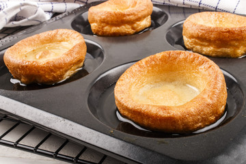 freshly baked yorkshire pudding in baking tray with sunflower oi