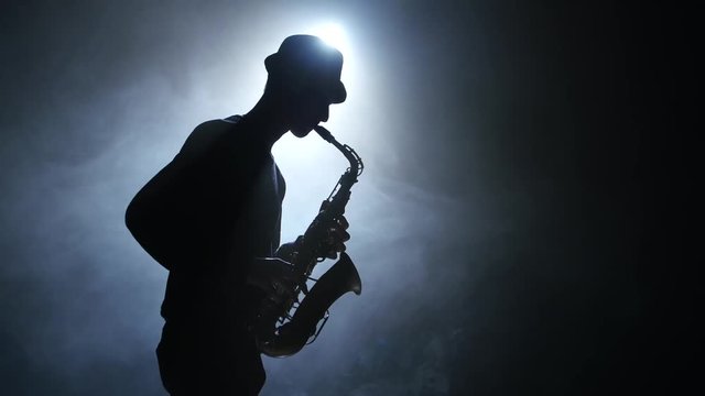 Solo concert of the actor playing on the saxophone. Smoke