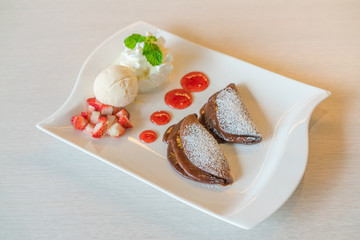 Pancake and fruit with ice cream on table .