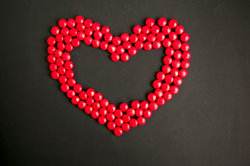 Red candy Heart shape over black background