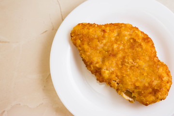 Chicken breast in breadcrumbs on a white plate