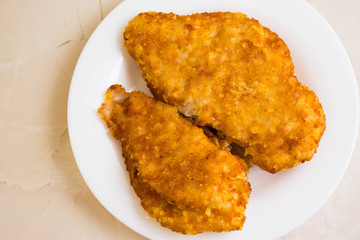 Chicken breast in breadcrumbs on a white plate