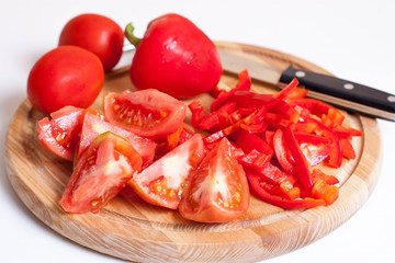 Fresh vegetables on cutting board in a wooden kitchen table