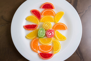 Multicolored fruit jellies on a white plate. Delicious and beautiful dessert.