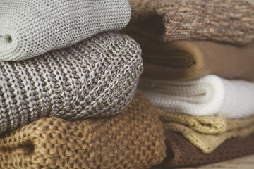 tinted image two stacks of warm sweaters on the table on a light
