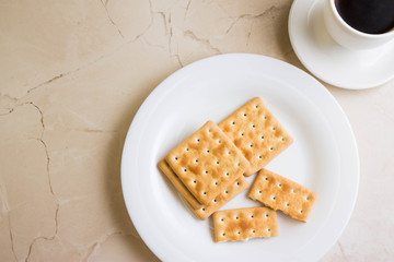 Crackers on a white plate and coffee. Tasty and nutritious breakfast.
