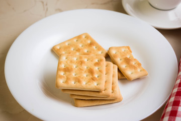 Crackers on a white plate and coffee. Tasty and nutritious breakfast.