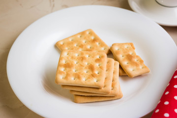 Fototapeta na wymiar Crackers on a white plate and coffee. Tasty and nutritious breakfast.