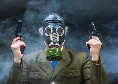 Portrait of a soldier in a gas mask with a gun on a black background isolated