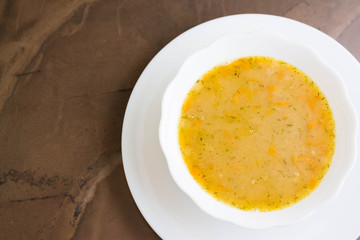 Pea soup in a white bowl on a marble table