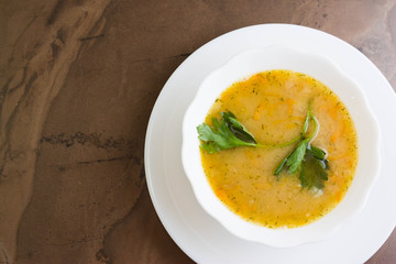 Pea soup in a white bowl on a marble table