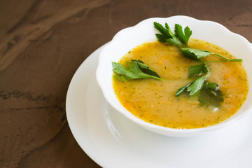 Pea soup in a white bowl on a marble table