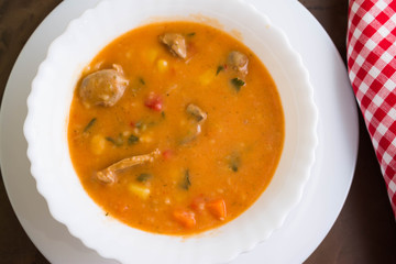 Tomato soup with chicken giblets in a white bowl