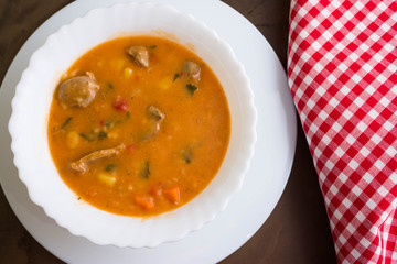 Tomato soup with chicken giblets in a white bowl