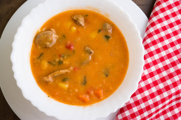 Tomato soup with chicken giblets in a white bowl