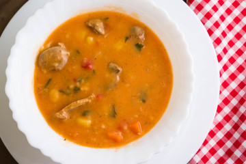 Tomato soup with chicken giblets in a white bowl