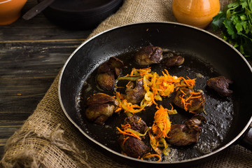 Fried chicken liver with vegetables in a frying pan