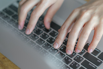 Closeup of business woman hand typing on laptop keyboard .