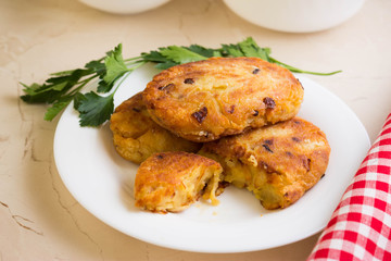 Potato patties with fried onions on a white plate