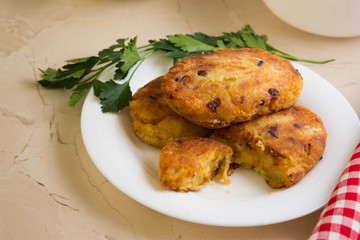 Potato patties with fried onions on a white plate