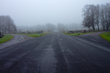 Fototapeta premium Old cemetery headstones on a foggy day