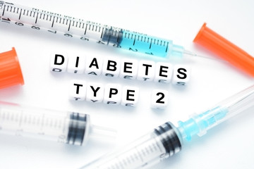 Type 2 diabetes text spelled with plastic letter beads placed next to an insulin syringe
