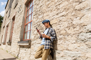 Fototapeta premium man with smartphone drinking coffee on city street