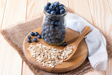 Fototapeta na wymiar Raw oatmeal with fresh blueberries on a cutting board