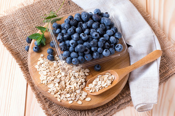 Raw oatmeal with fresh blueberries on the board