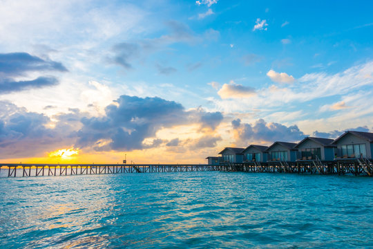 Beautiful sunrise with  water villas  in tropical Maldives islan