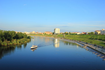 Obraz premium The ship floats on the river Tour along the waterfront, in the centre of Tyumen city in clear weather