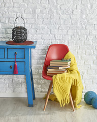 blue vintage desk and red chair brick wall concept