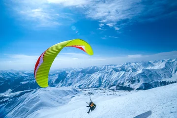 Fototapeten Winter in Greater Caucasus Mountains. Georgia (country). Gudauri ski resort. Paragliding © phototravelua