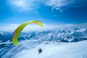 Tuinposter Winter in Greater Caucasus Mountains. Georgia (country). Gudauri ski resort. Paragliding © phototravelua