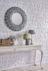 beautiful mirror on the brick wall and vintage table concept