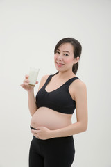 Pregnant Woman Standing and Holding a Glass of Milk