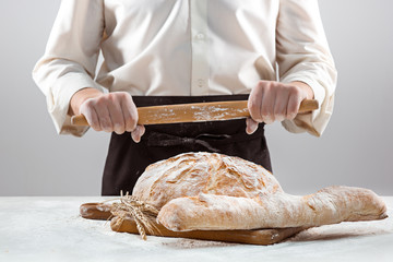 The male hands and rustic organic loaf of bread
