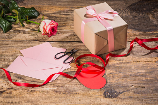 The gift box with hearts on wooden background