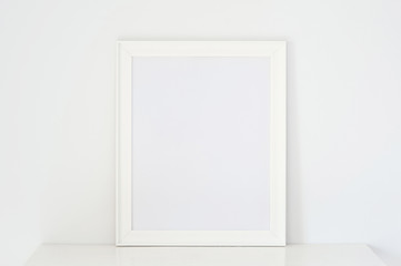 Frame white on white wooden table, put walls white background.