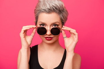 Trendy young woman portrait with short hair and round sunglasses