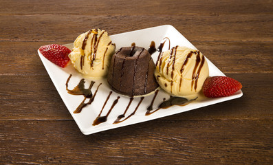 Petit gateau dessert with ice cream and strawberry on wooden bac