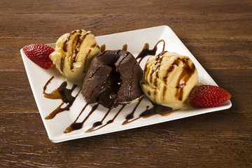 Petit gateau dessert with ice cream and strawberry on wooden bac