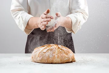 Rolgordijnen The male hands in flour and rustic organic loaf of bread © master1305