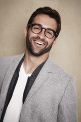 Happy guy in spectacles in grey coat, portrait