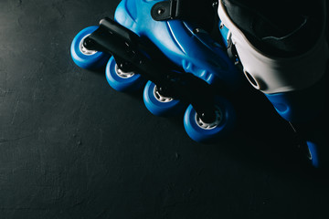 Close up view of blue roller skates inline skate or rollerblade on dark tinted grunge background