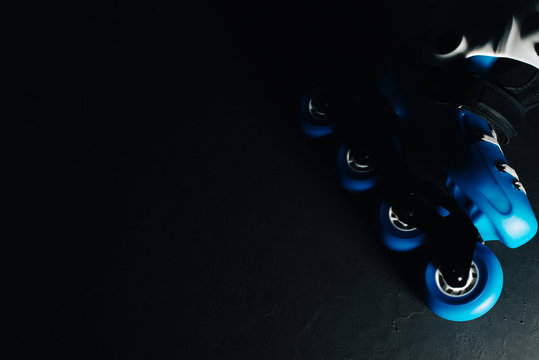 Close up view of blue roller skates inline skate or rollerblade on dark tinted grunge background