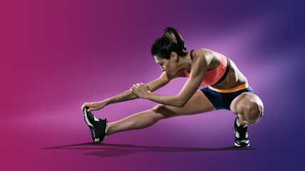 Sport. Young woman stretching her leg.