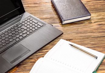 Laptop with notepad on the desk. Workspace in office.