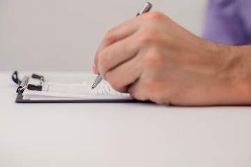 Fototapeta premium Close up of the hands of a businessman in a suit signing or writing